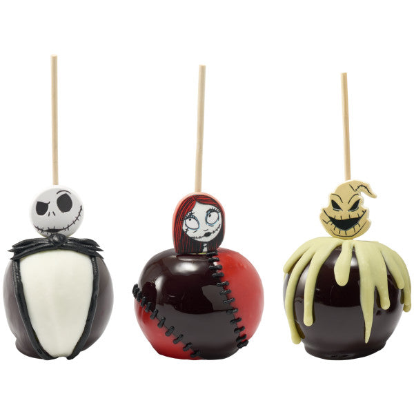 Three candy apples decorated with Nightmare Before Christmas character toppers, featuring Jack Skellington, Sally, and Oogie Boogie with coordinating colored designs.