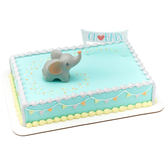 Rectangular baby shower cake decorated with light blue frosting, featuring a gray elephant topper and “Oh Baby” banner in the corner.
