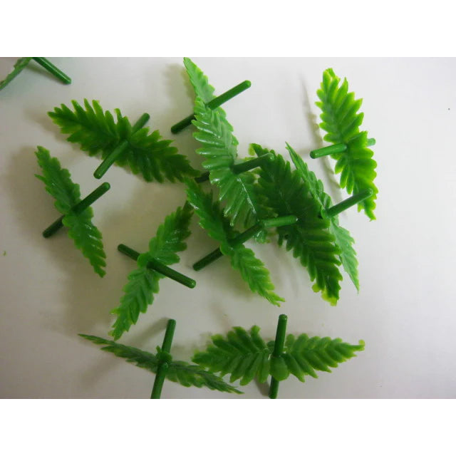 Plastic orange marzipan leaf picks with textured detail and green stems, used for candy decorating or confectionery accents.