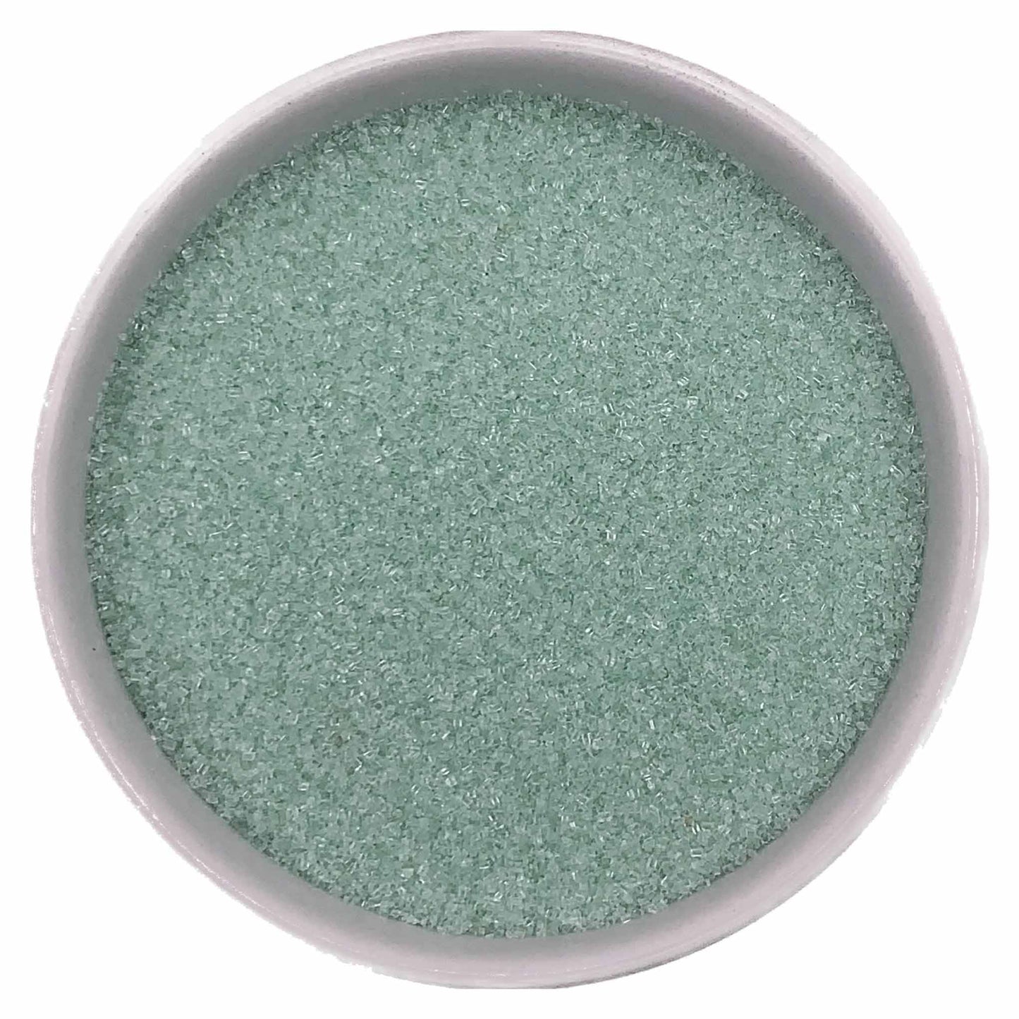Top-down view of a white bowl filled with pastel green fine sanding sugar, showing tiny pale mint-green crystals with a soft shimmering texture.
