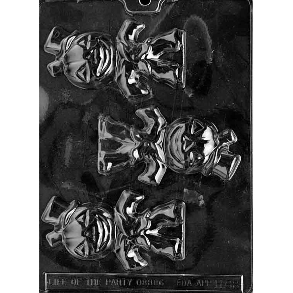 Clear plastic chocolate mold photographed on a black background with three pumpkin-headed character cavities, each showing a jack-o’-lantern face, bow tie, and flared costume shape.