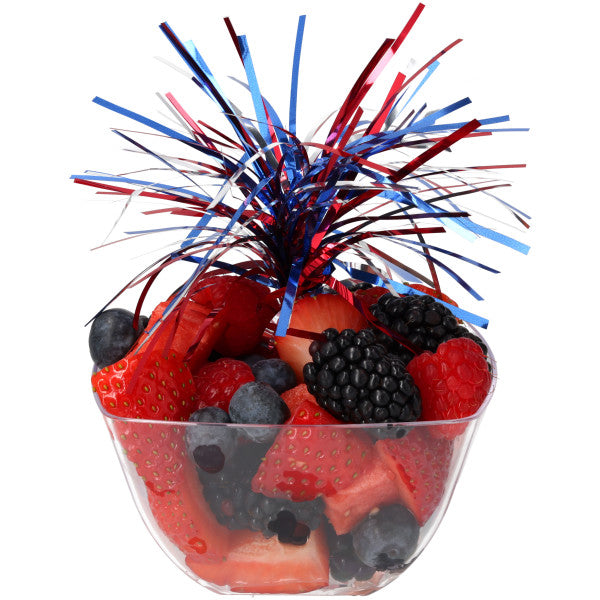 Fresh mixed berries in a clear cup with red, white, and blue pom-pom party pick.