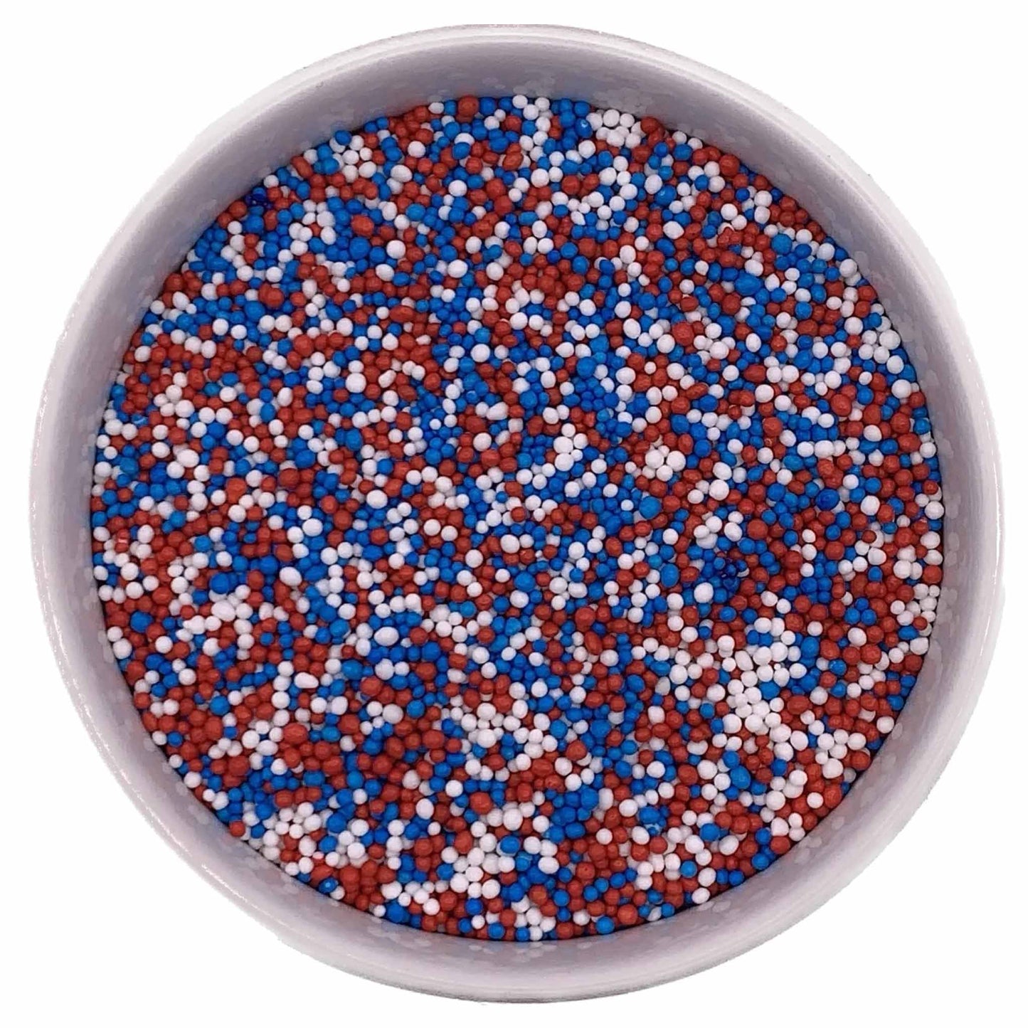 Bowl of red, white, and blue nonpareil sprinkles (All American mix) on a white background.