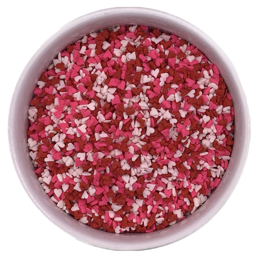 Bowl filled with red, pink, and white mini heart sprinkles, perfect for decorating Valentine's Day cupcakes, cookies, and cakes.
