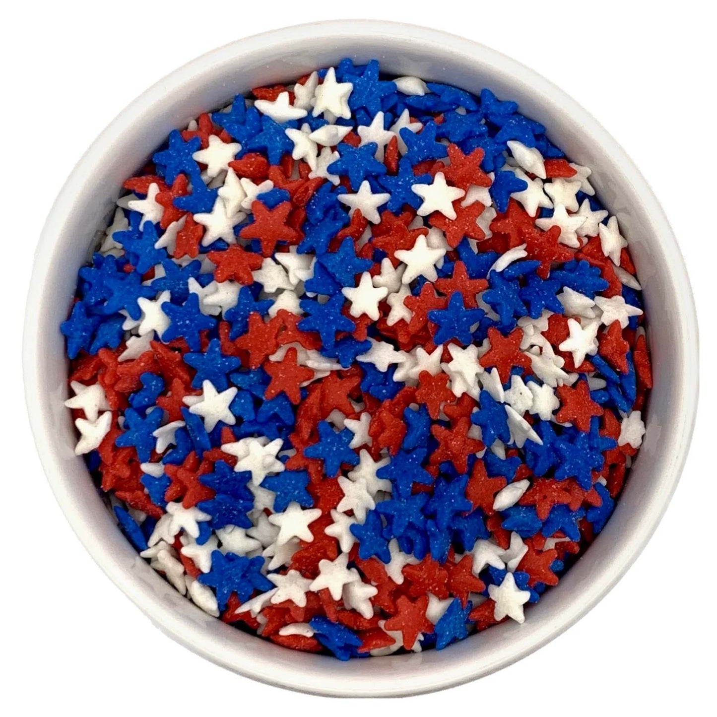 White bowl filled with miniature star sprinkles in bright red, royal blue, and white, shown in a close-up top view.
