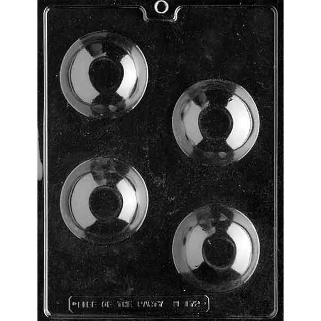 Clear chocolate mold with four large round dome cavities arranged in alternating rows against a dark background, each with a smooth curved surface.
