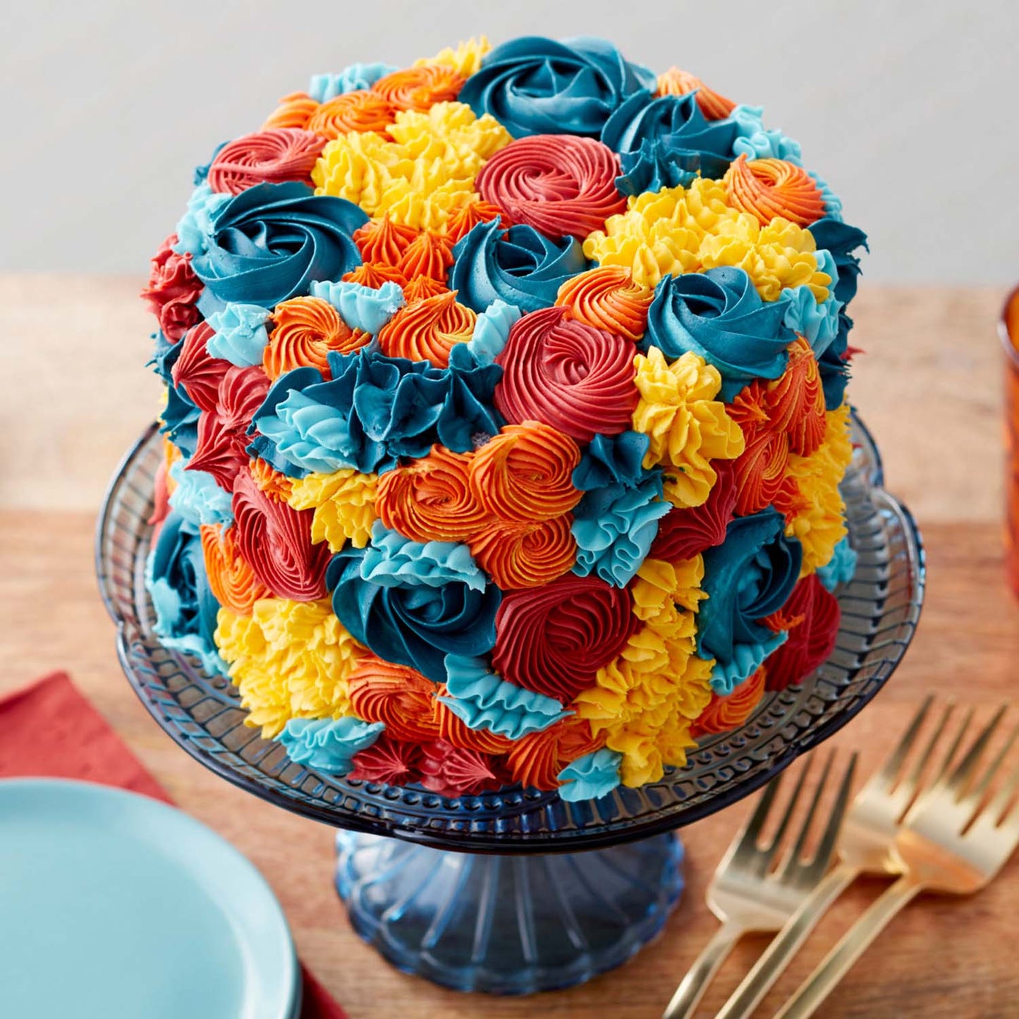 Colorful piped buttercream floral cake displayed on a cake stand, ideal for showcasing turntable decorating results.