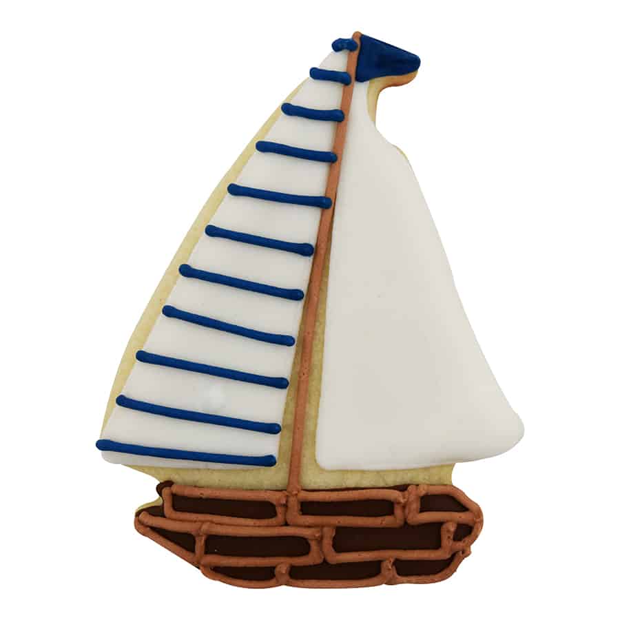 Sailboat-shaped cookie decorated with white and navy icing, featuring a wooden-style hull and classic sail detailing.