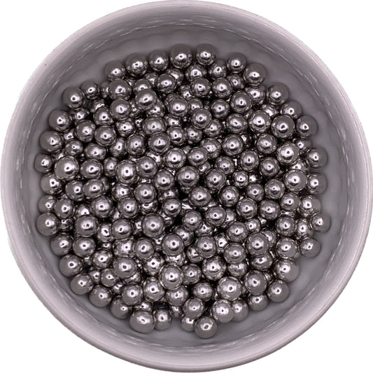 Silver dragees in a round container, 6mm size, with a shiny metallic finish for decorating cakes and cookies.