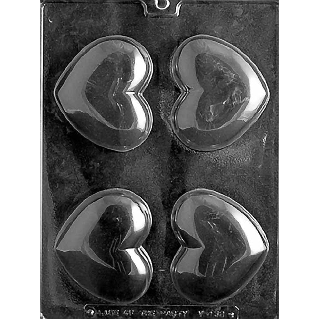 Clear plastic chocolate mold with four large smooth heart-shaped cavities, photographed on a dark background.