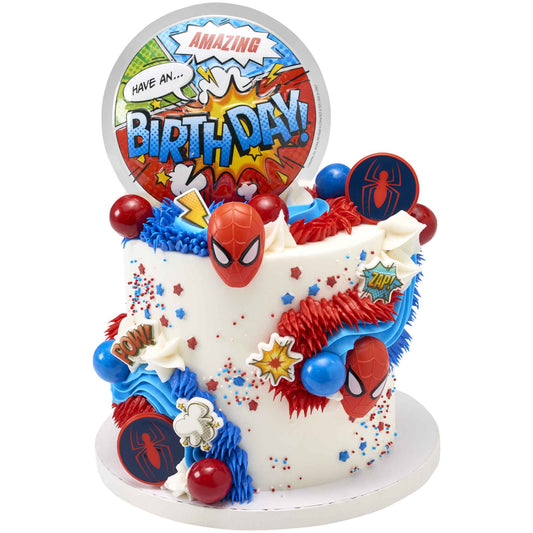 Spider-Man cupcake rings decorating a white comic book birthday cake with red and blue piping and a large birthday topper