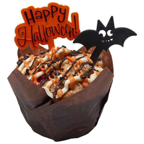 Muffin decorated with orange and white drizzle, Halloween sprinkles, and black bat and "Happy Halloween" picks.
