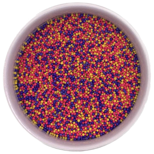 Bowl of Spring Mix non-pareils in pink, purple, and yellow colors, perfect for Easter and spring-themed dessert decorating.
