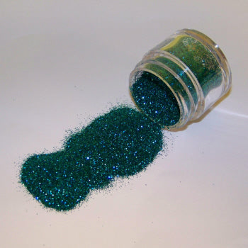 Rich teal Galaxy Glitter Dust pouring from a jar, sparkling with a mix of green and deep blue hues.