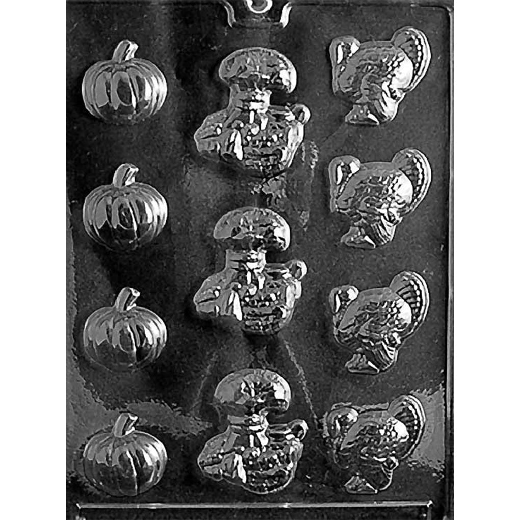 Clear plastic Thanksgiving chocolate mold with multiple cavities shaped like pumpkins, turkeys in profile, and a stacked harvest crops design featuring corn and wheat.