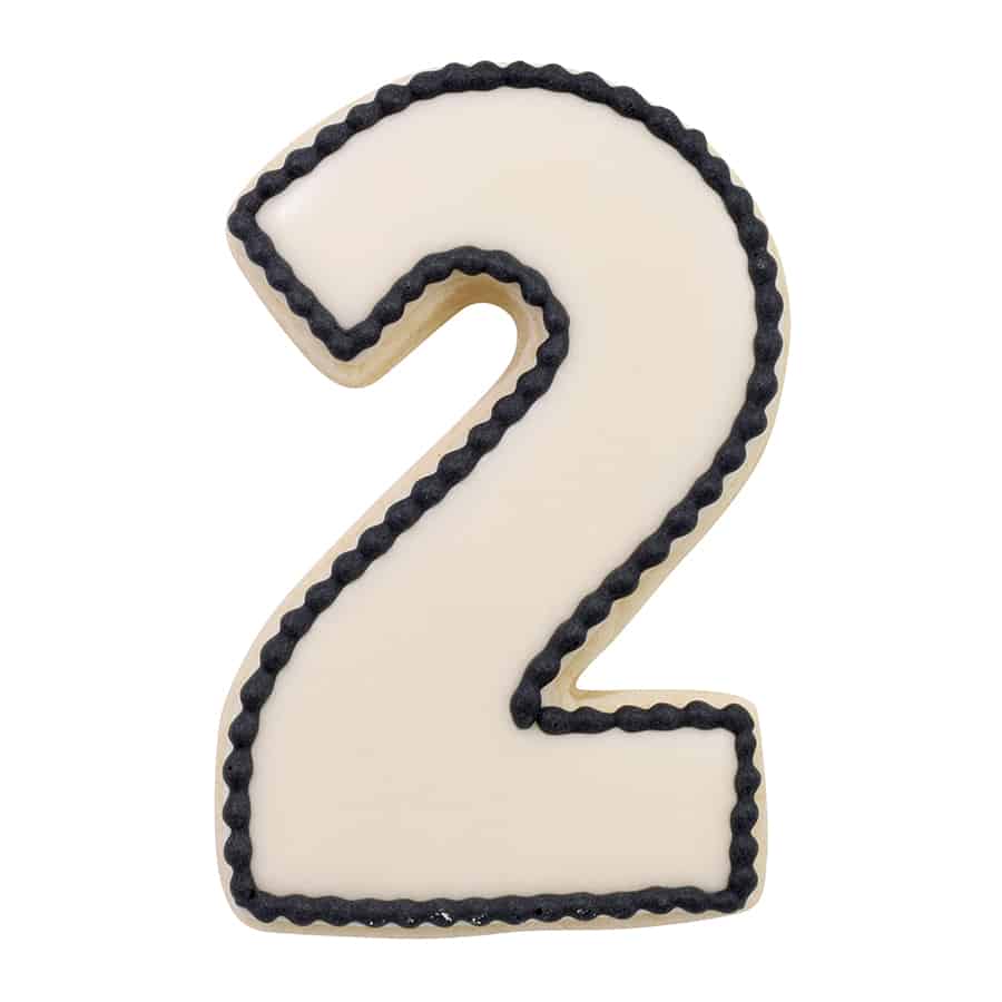 Number 2-shaped cookie decorated with white icing and a black piped border.