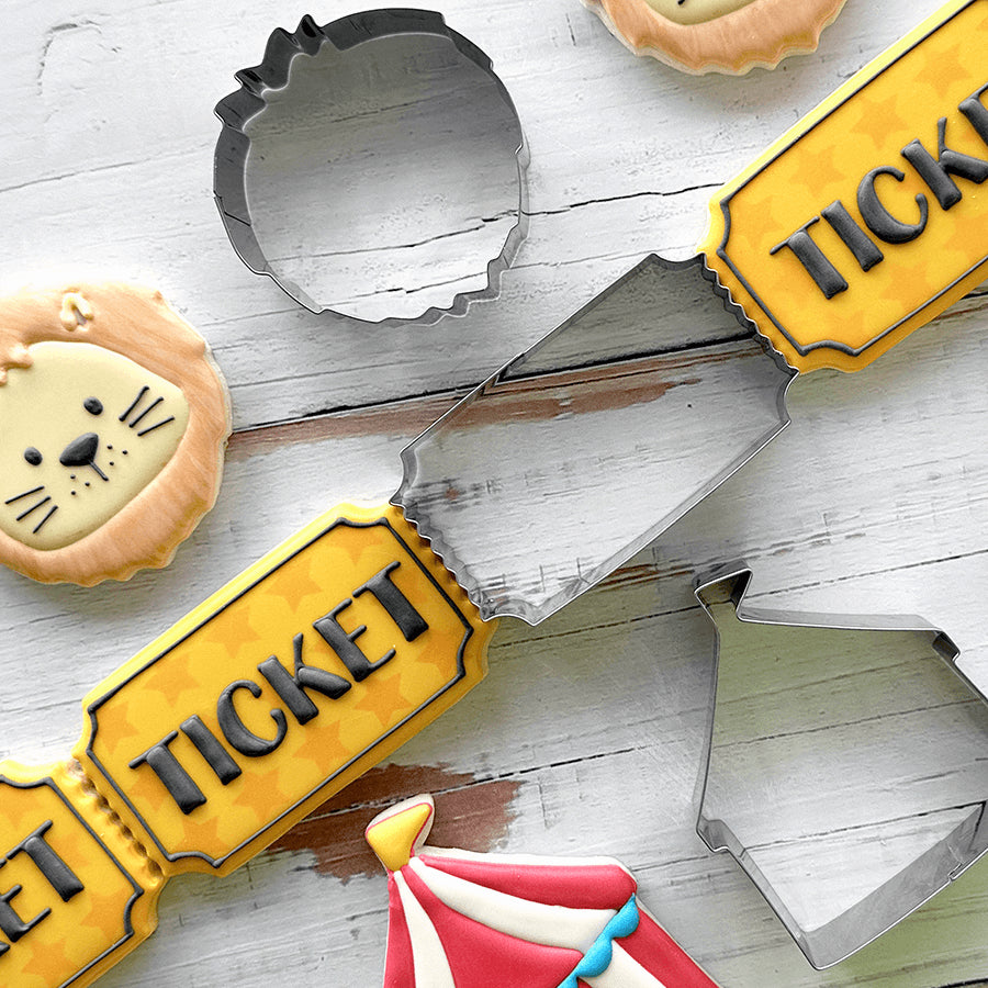 Decorated ticket-shaped cookies with a circus theme, featuring bold lettering and vibrant colors.