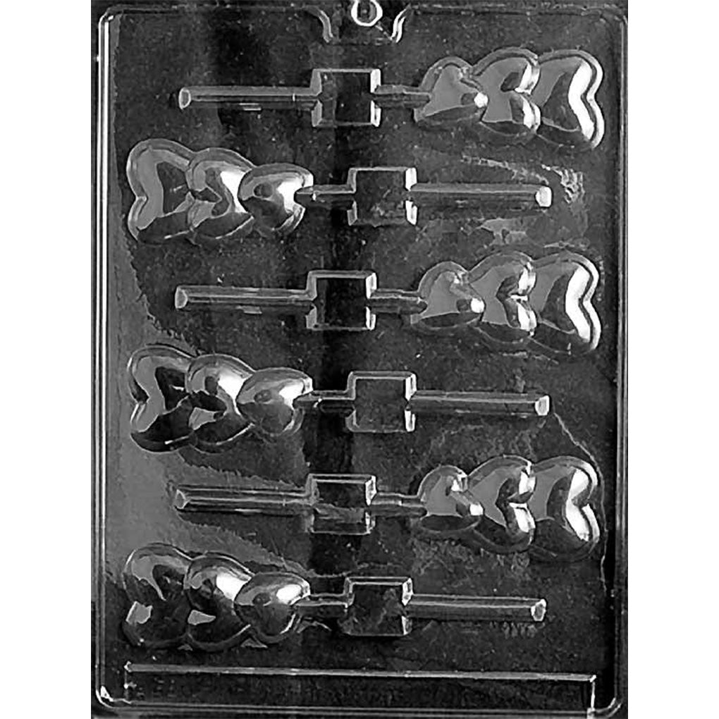 Clear Triple Hearts Chocolate Lollipop Mold photographed against a black background with six lollipop cavities, each featuring three overlapping heart shapes and a stick channel.
