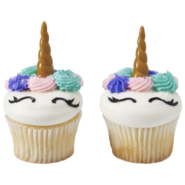 Cupcakes decorated with unicorn horn picks, pastel frosting rosettes, and eyelash piped designs.