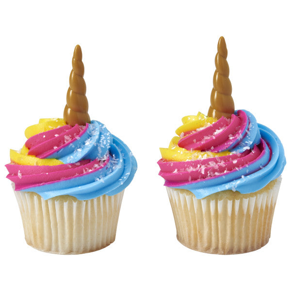 Cupcakes with bright pink, yellow, and blue frosting swirls topped with unicorn horn picks.