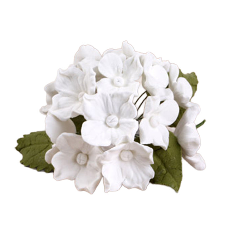 White gum paste hydrangea flower bunch with layered white blossoms and green leaves arranged in a compact cluster on a white background.
