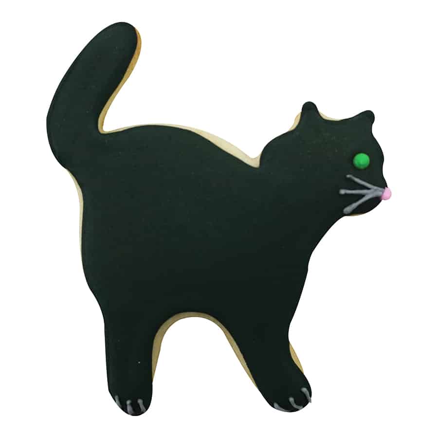 Decorated cat-shaped cookie with black icing, green eyes, and whiskers, resembling a Halloween cat.