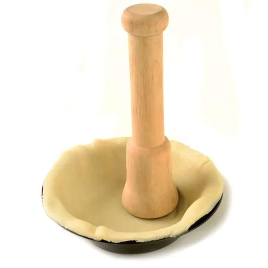 Pastry tamper pressing dough into a small tart shell.