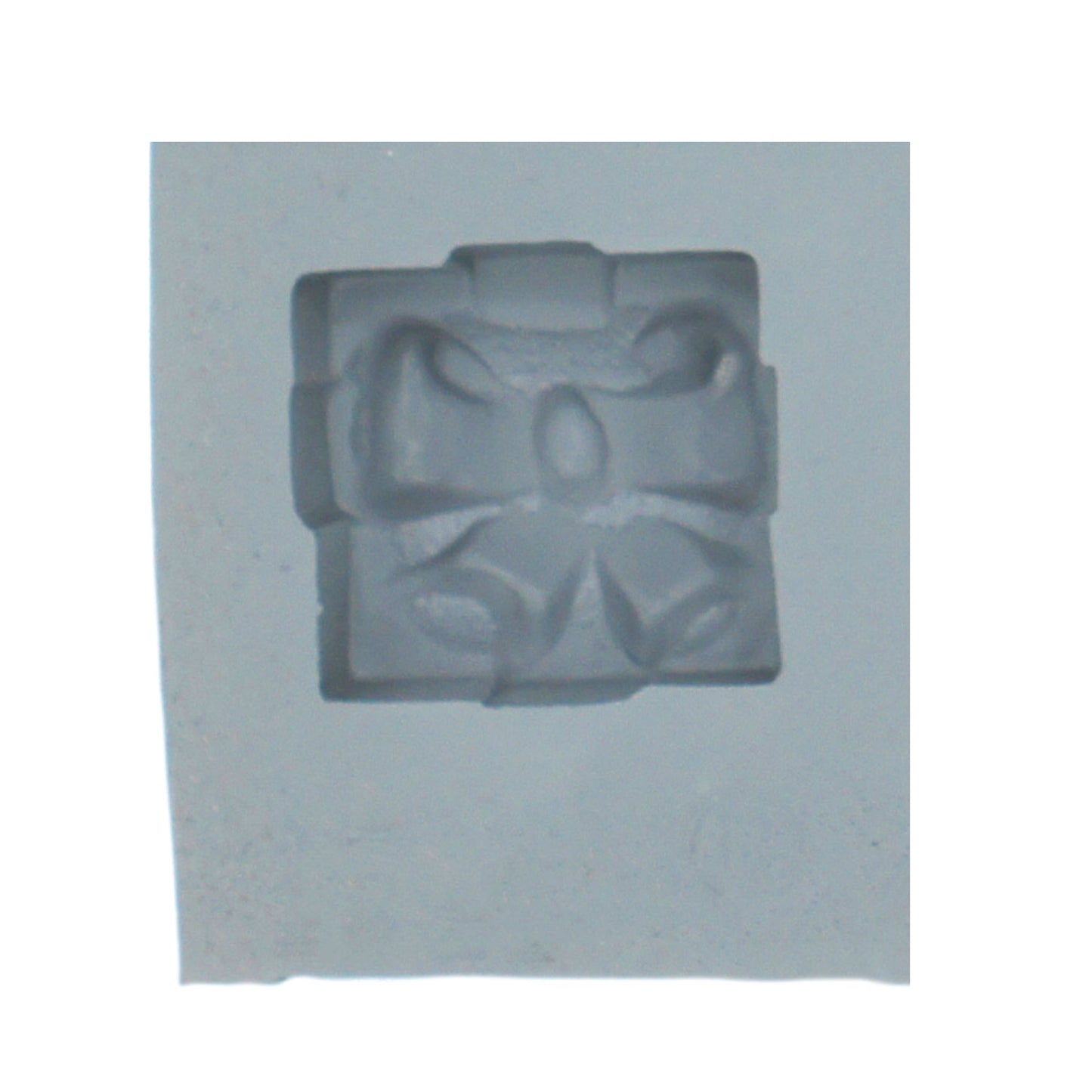 Close-up of Christmas present rubber mint mold featuring a detailed gift box with bow design