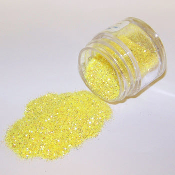 Bright yellow Galaxy Glitter Dust spilled from a clear jar, sparkling with vibrant citrus tones and iridescent flecks on a white background.
