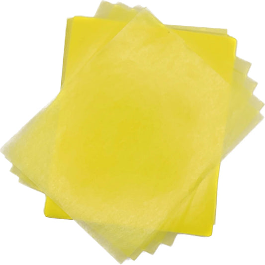 Overlapping stack of bright yellow 4" x 5" wax caramel and taffy wrapper sheets arranged on a white background.