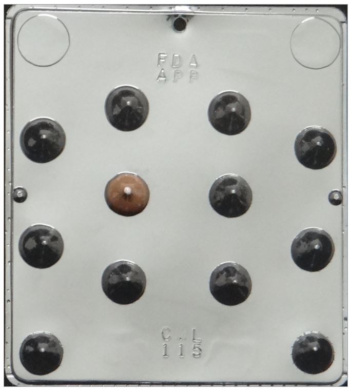 A 12-cavity plastic chocolate mold featuring kiss-shaped cavities in a 3x4 grid, with one cavity filled with a brown chocolate piece; mold has a shiny, reflective silver finish and embossed text markings for FDA approval and mold identification.