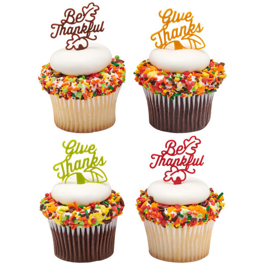 Cupcakes topped with fall sprinkles and colorful Thanksgiving picks that say “Give Thanks” and “Be Thankful.”
