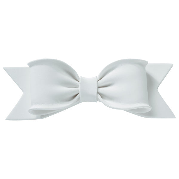 Front view of a large white gum paste bow with realistic folds and ribbon tails, designed for cake decorating.