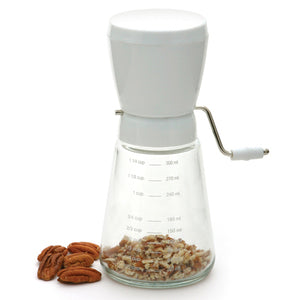 Manual nut chopper with a glass measuring base and stainless steel blades, designed for both hard and soft nuts.