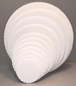 White scalloped corrugated plastic cake board, available in multiple sizes, designed for strong support and clean presentation of decorated cakes.