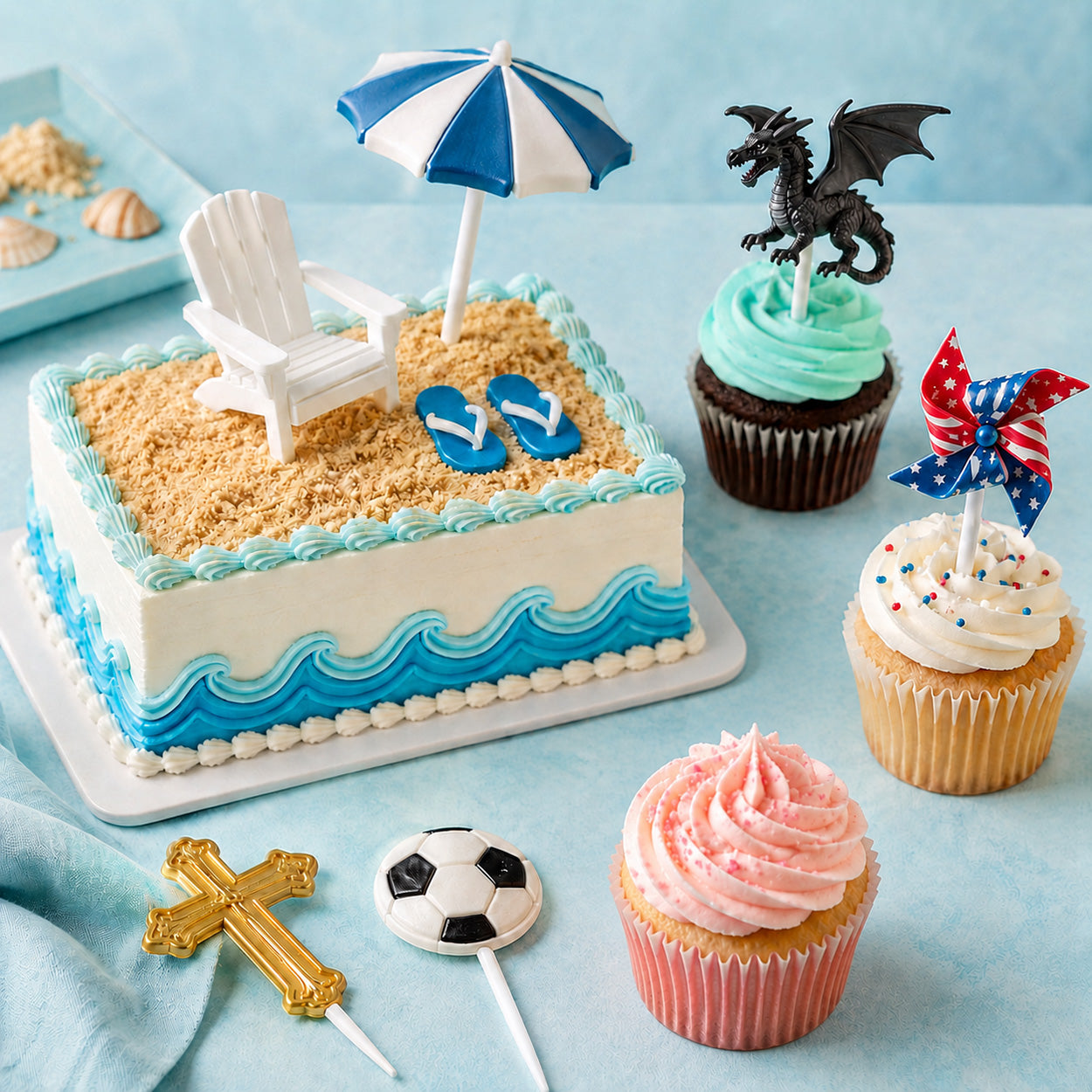 Beach-themed birthday cake and cupcakes with umbrella, flip-flops, dragon topper, butterfly pick, and sports candy pops.
