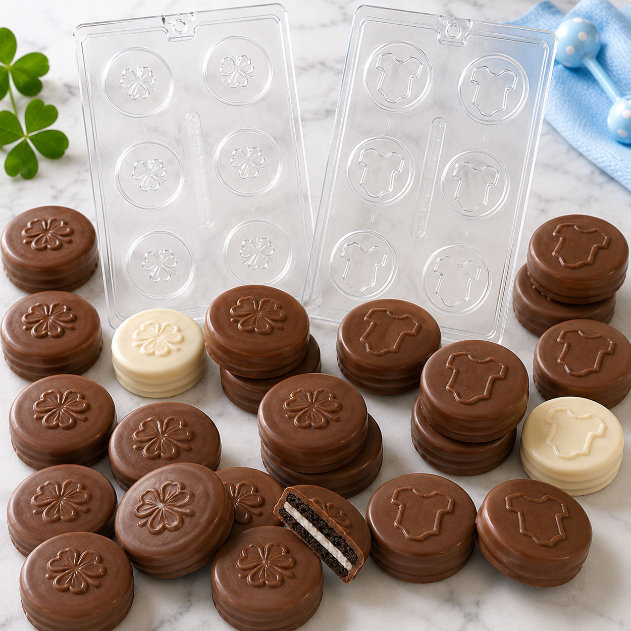 St. Patrick's Day chocolate covered oreo sandwich cookie molds with shamrock and baby bodysuit designs, plus finished milk and white chocolate cookie treats.