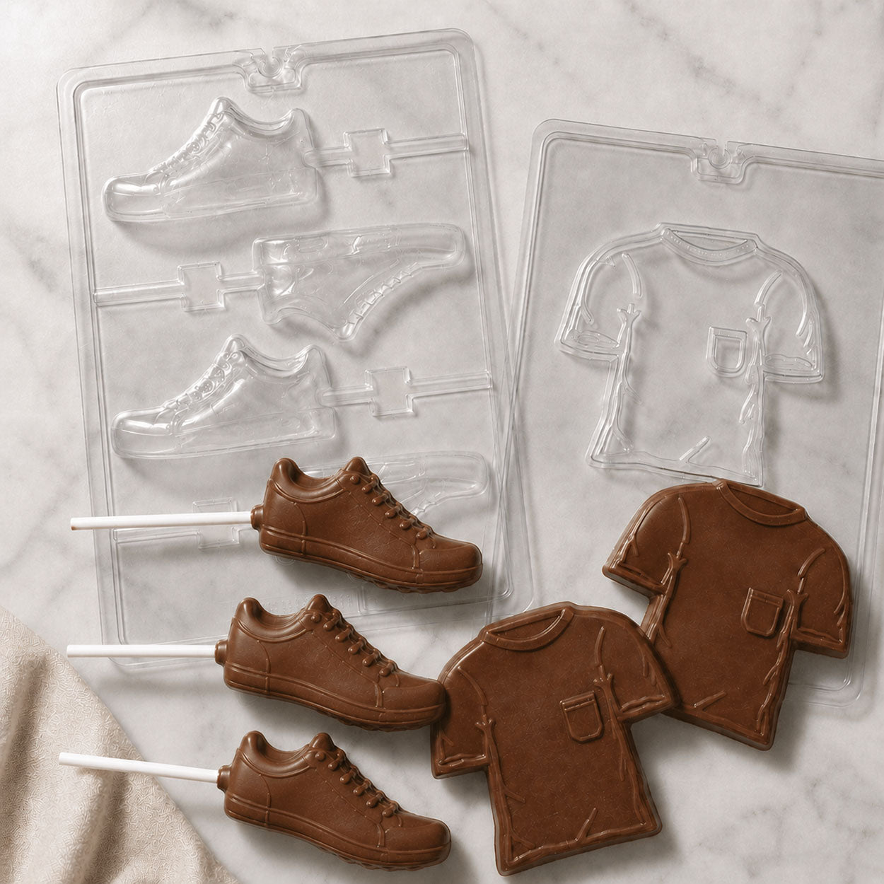 Sneaker and T-shirt chocolate candy molds with finished milk chocolate sneaker lollipops and T-shirt chocolates for sports, fashion, or party-themed treats.