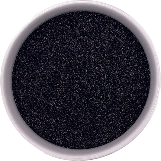 Close-up of fine black sanding sugar crystals with a deep matte sparkle, ideal for decorating cookies and cupcakes.