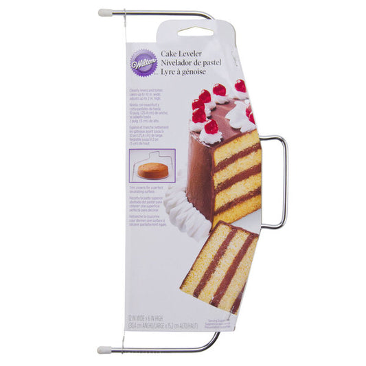 Wilton adjustable wire cake slicer shown in retail packaging with a metal frame, integrated side handle, rubber-capped feet, and thin cutting wire; package features a tall chocolate layer cake image.