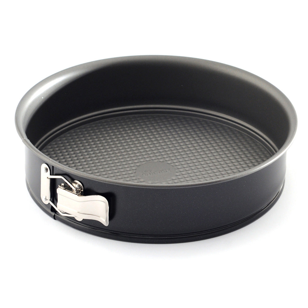 Black 10-inch nonstick springform pan with tall round sides, textured removable base, and silver spring latch photographed on a white background.