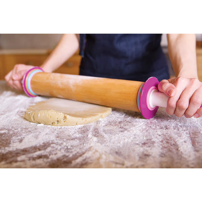 Person using the adjustable rolling pin to roll out dough on a floured surface