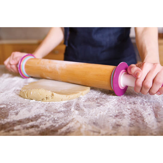 Person using the adjustable rolling pin to roll out dough on a floured surface
