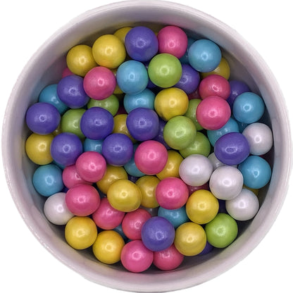 This image features a vibrant assortment of round, multicolored sugar pearls in a variety of colors including yellow, green, pink, purple, blue, and white. These decorative edible pearls are perfect for adding a pop of color and a touch of elegance to cakes, cupcakes, cookies, and other sweet treats.
