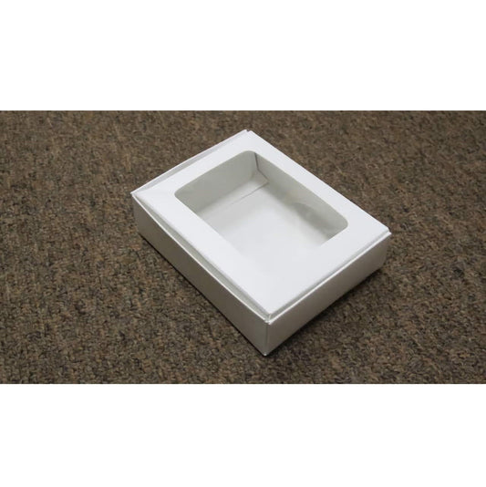 This image shows a 1/4 lb white candy box featuring a clear viewing window on the lid. The clean, white design of the box allows for versatility in use, perfect for any occasion where sweets are given as a gift or sold.
