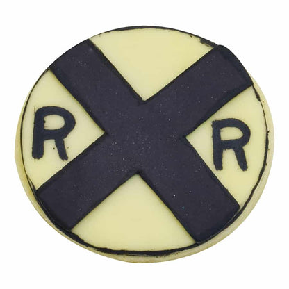 Round cookie decorated as a railroad crossing sign with black and yellow details.