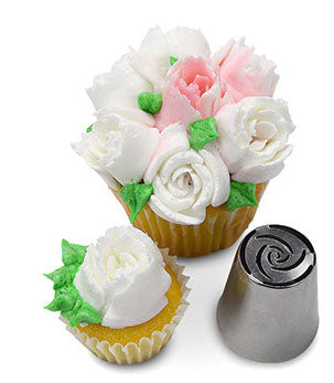 Cupcake featuring delicate white frosting flowers with hints of green leaves, created using Russian Piping Tip #243. The metal piping tip is placed next to the cupcake, demonstrating its unique design.