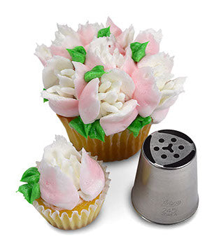 Cupcake decorated with intricate white and pink frosting flowers and green leaves, crafted using Russian Piping Tip #245. The piping tip tool is displayed next to the cupcake, showcasing its detailed design.
