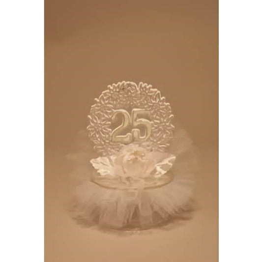 Graceful 25th-anniversary cake topper featuring the number '25' in a shimmering silver finish, set against a backdrop of a detailed wreath design with a delicate white flower and tulle decoration at its base, perfect for silver jubilee celebrations.