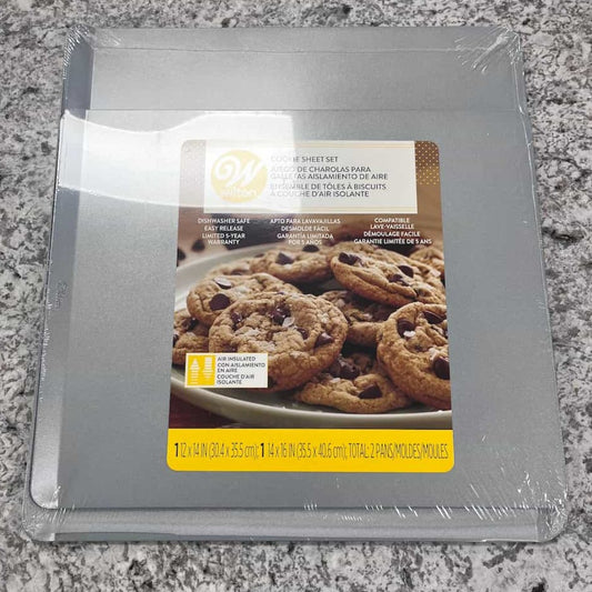This set includes two air-insulated cookie sheets designed for even baking. The packaging shows freshly baked cookies, highlighting the quality and functionality of the pans for baking enthusiasts.